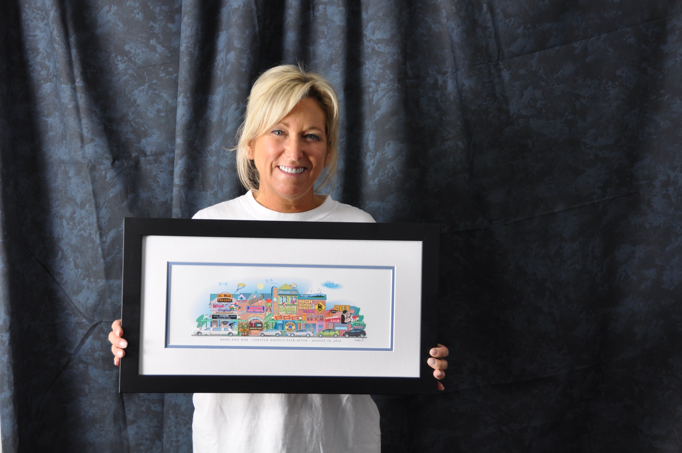 A woman holding her framed Your Memory Lane 3-building birthday street print.