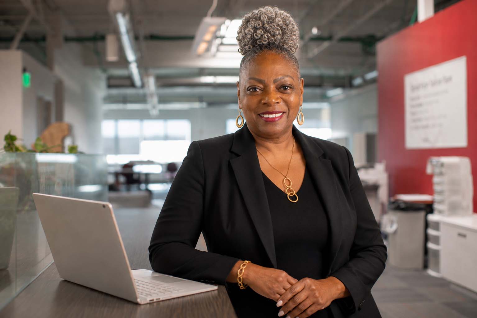 Dr. Angela E. Addison standing at her desk with a book
