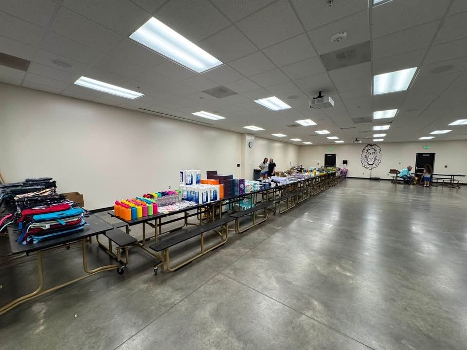 Tables of backpacks and school supplies set up before the giveaway