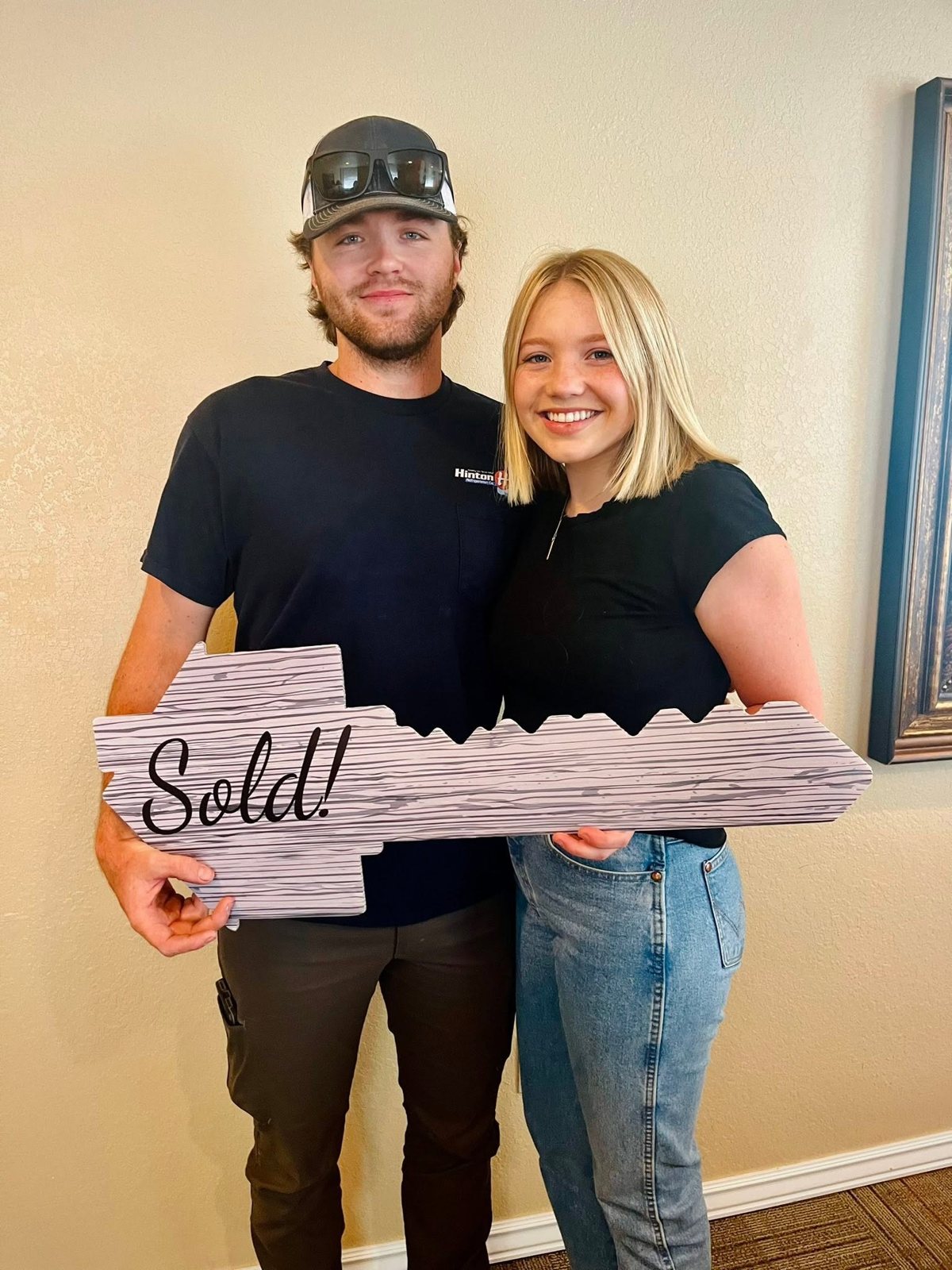 Cheyanne and her husband Travis holding a Sold key after buying their first home