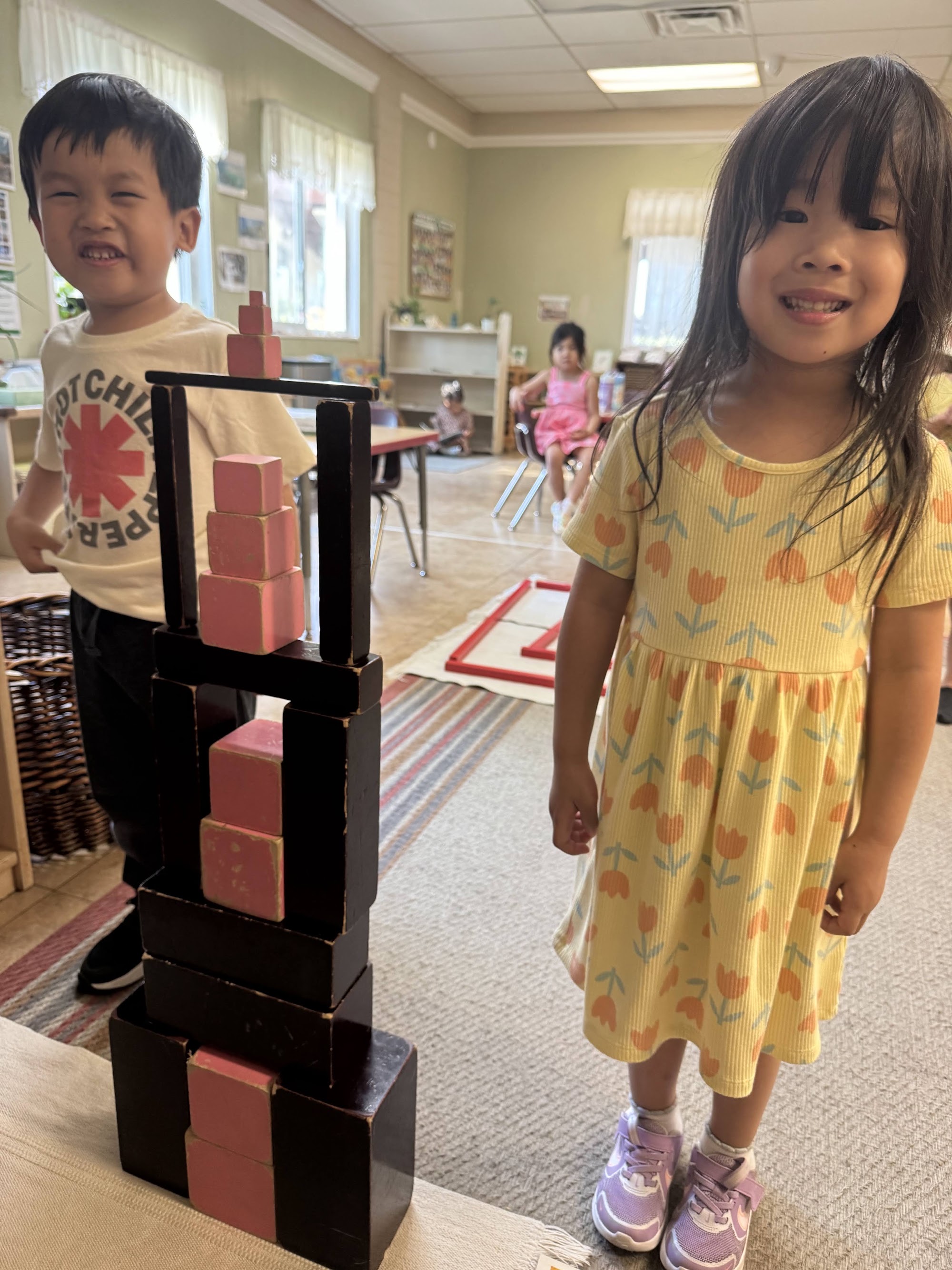 Two Montessori of Brea children beside the Pink Tower and Brown Stair they built