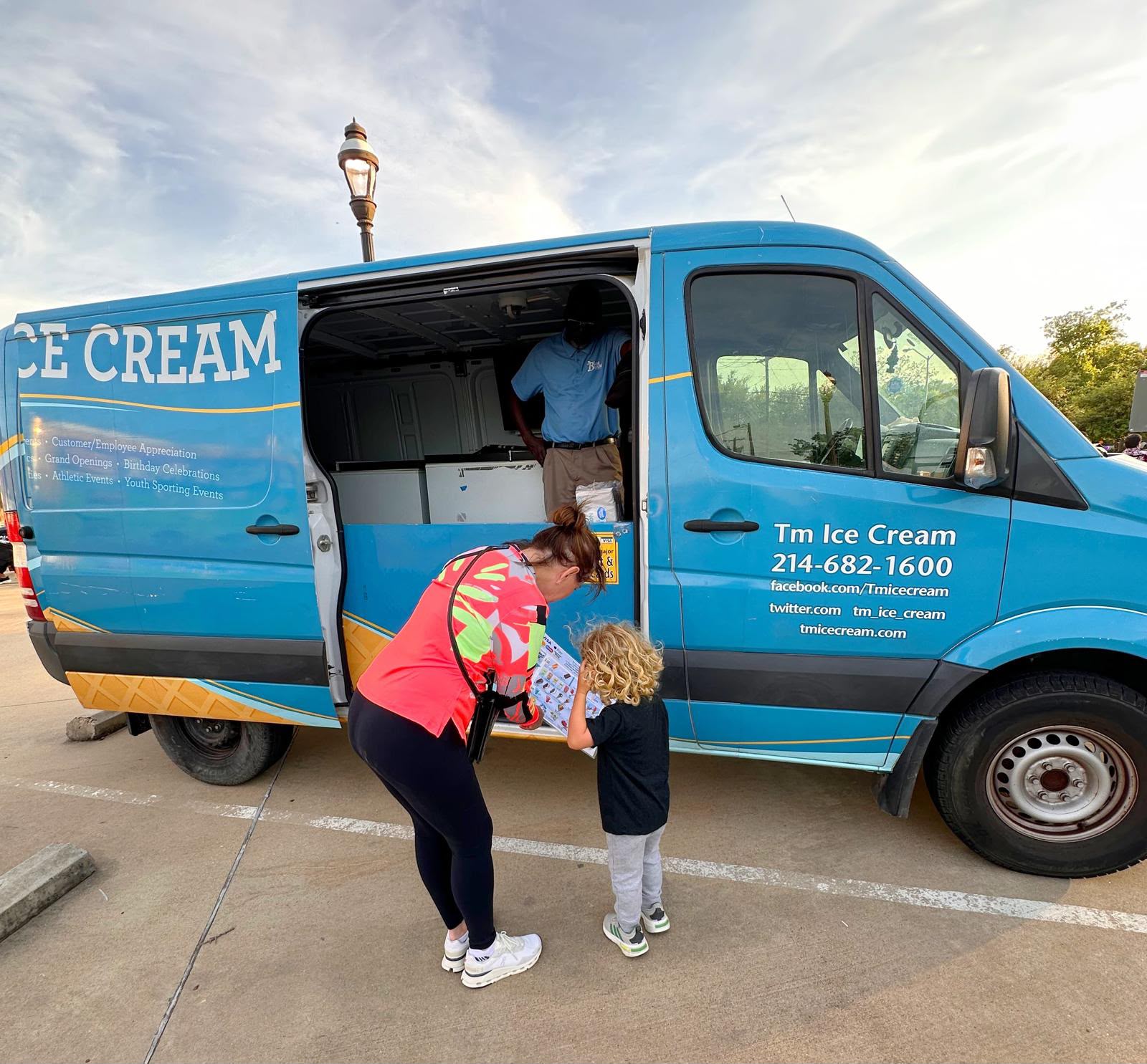Ice cream truck serving a line of families