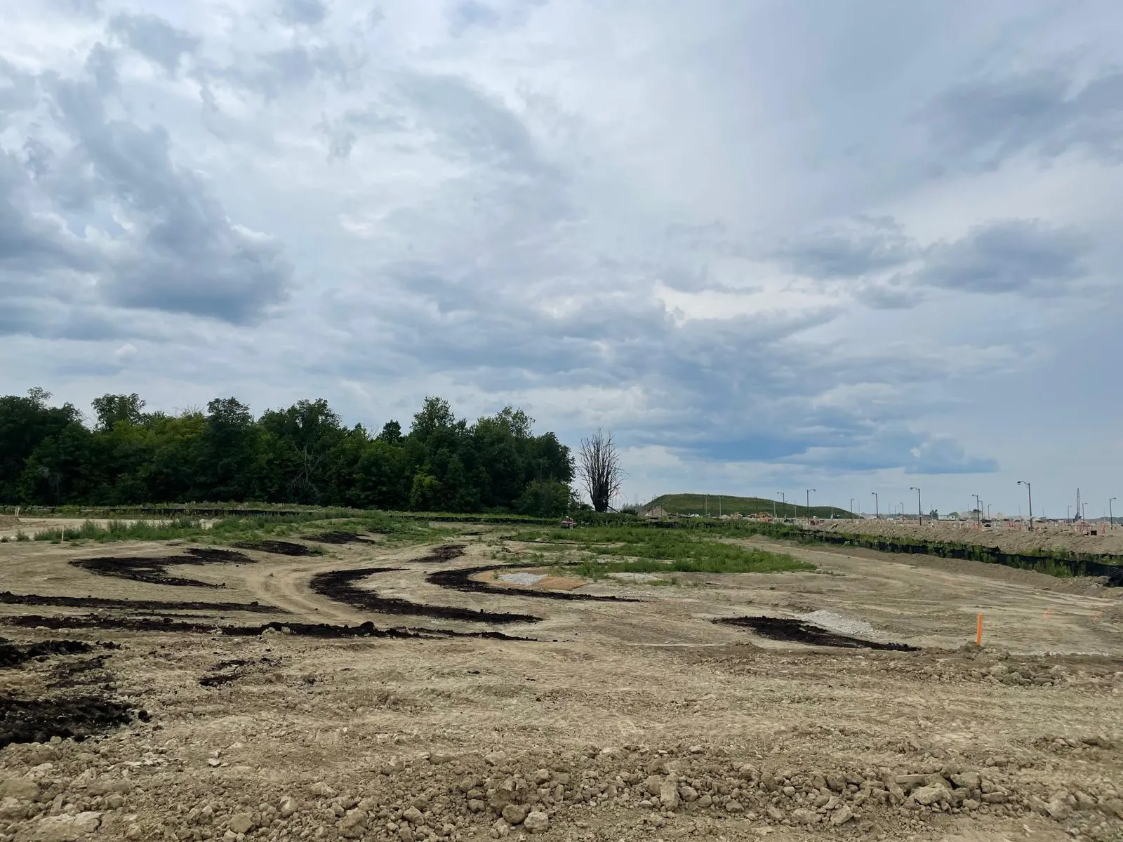 Excavator performing site preparation and grading on a GTA project