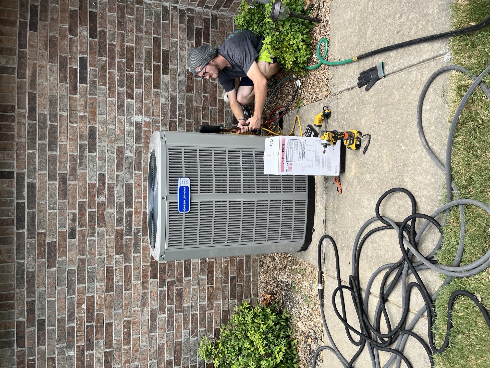 AC repair technician working on residential unit in Bentonville Arkansas
