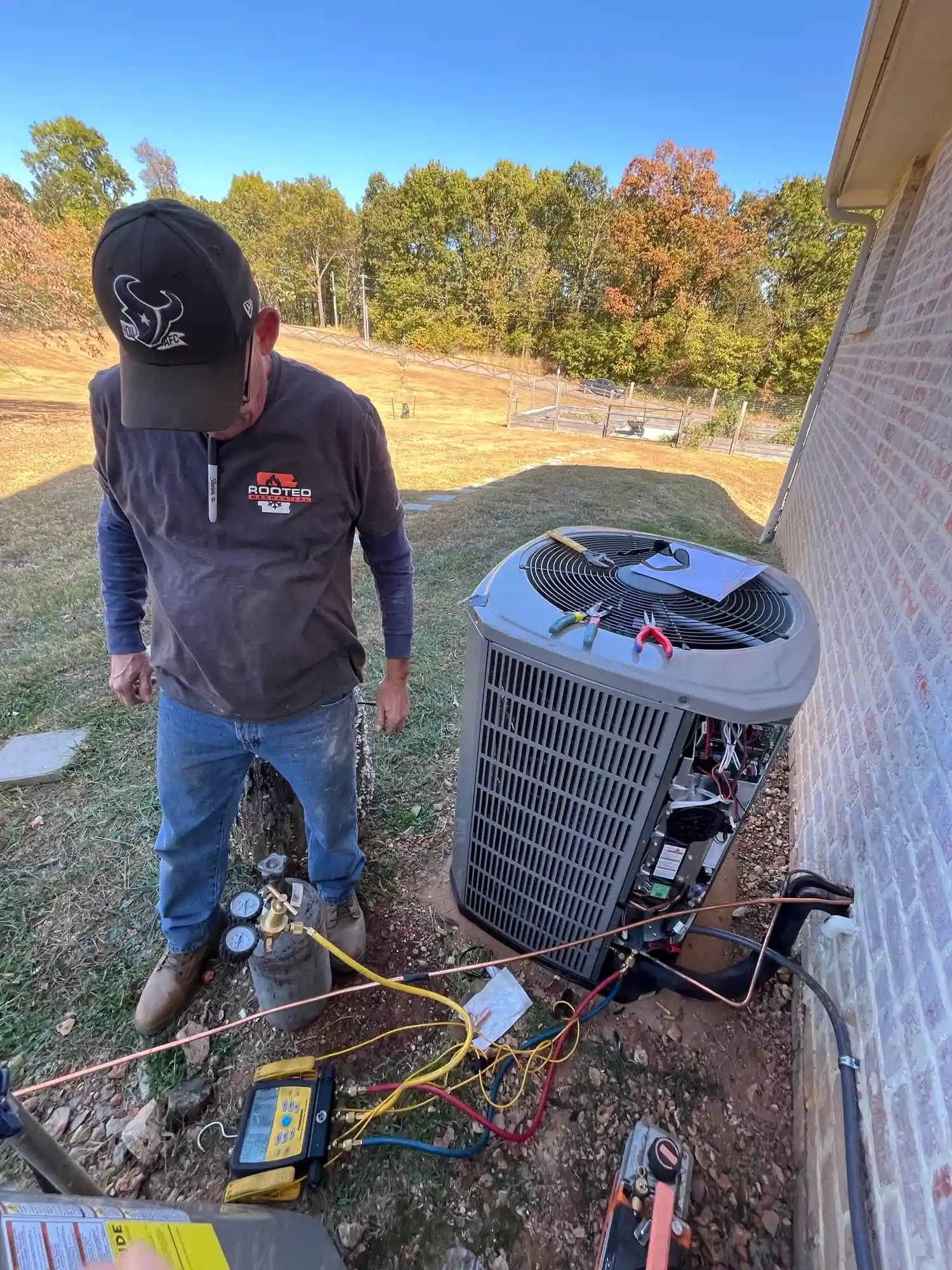 Older outdoor AC condenser being inspected for repair or replacement