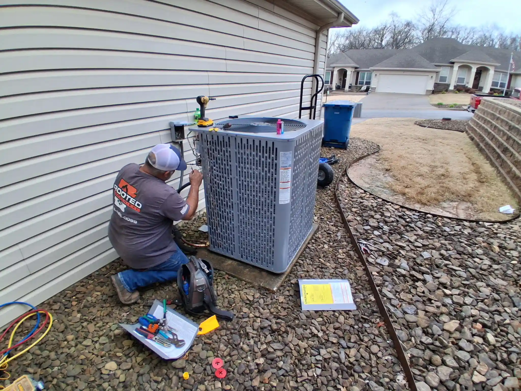 AC technician working on an outdoor condenser in Northwest Arkansas