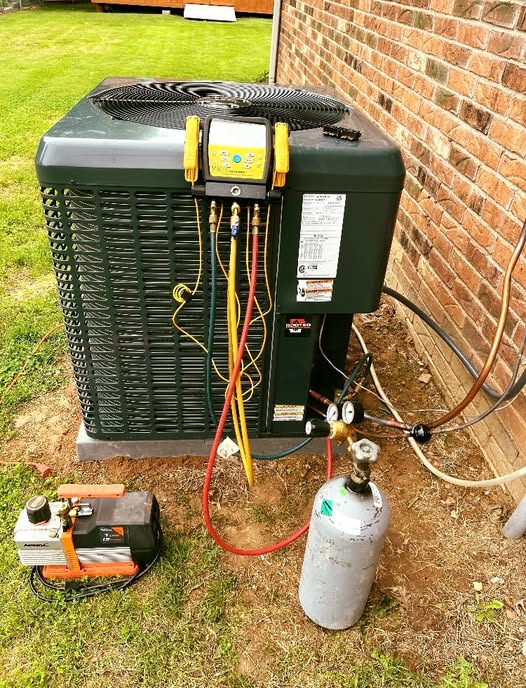 HVAC technician installing residential AC unit in Rogers Arkansas