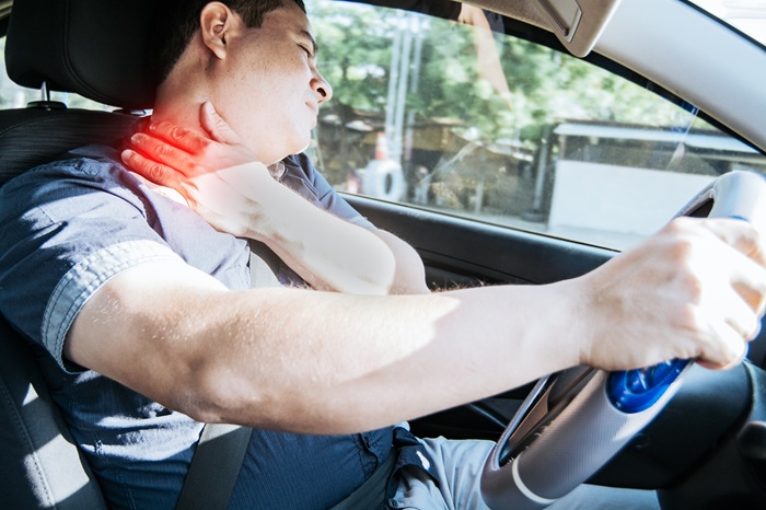 Person experiencing neck pain and stiffness from whiplash in Tucson AZ