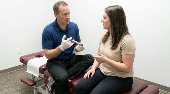 chiropractor explaining to a patient how the activator method works