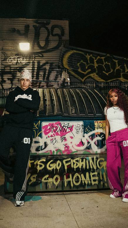 Models posed against a painted graffiti wall