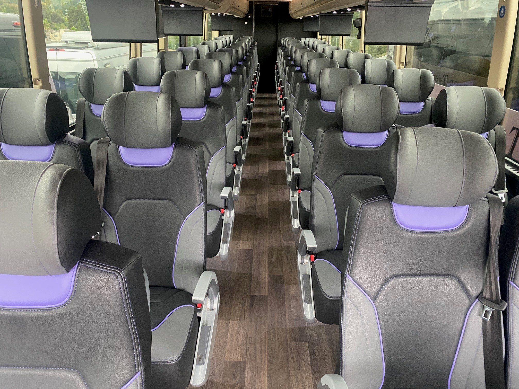 Inside the motorcoach: reclining leather seats and wide windows.