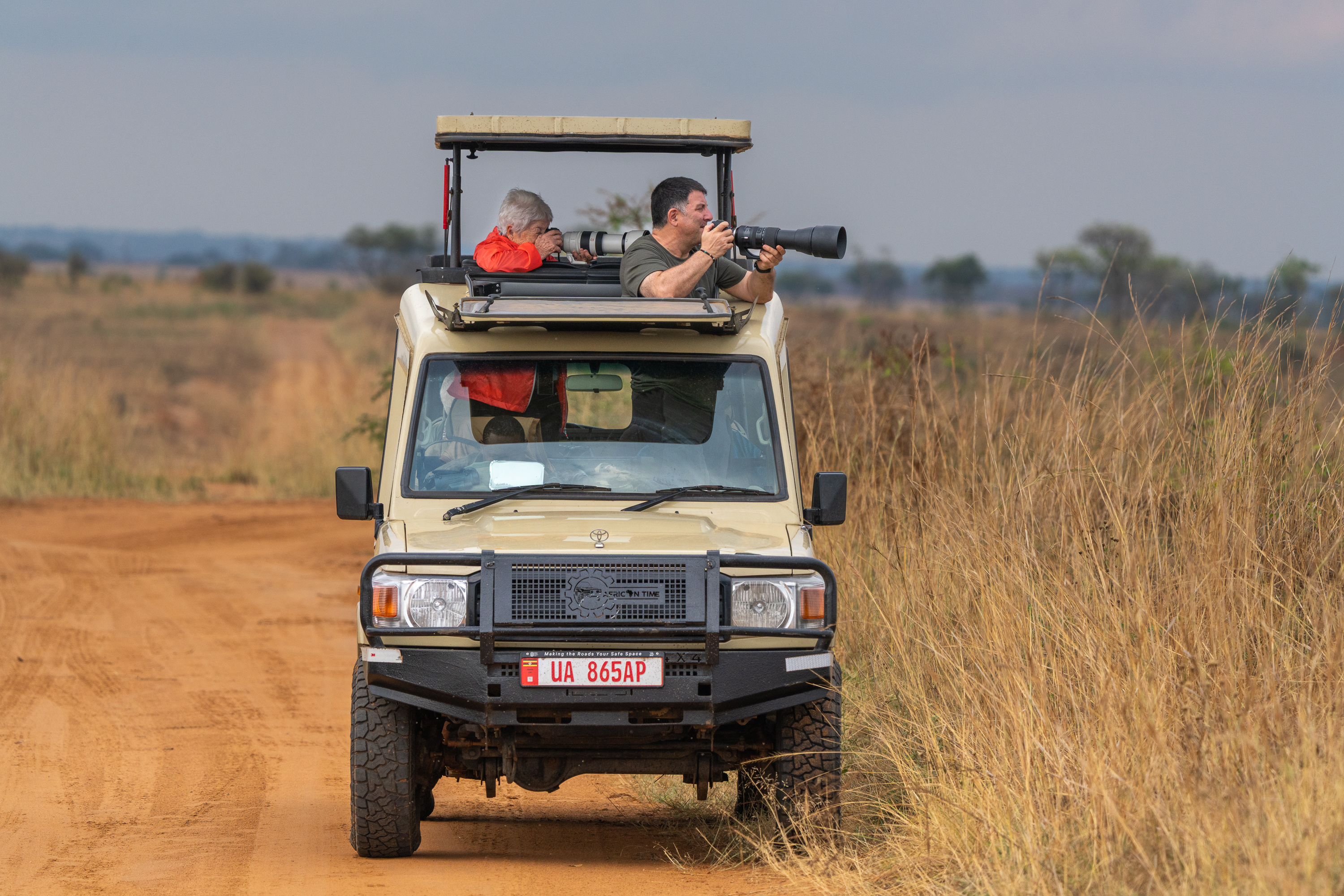 Viajeros en el techo de un vehículo de safari recorriendo Uganda