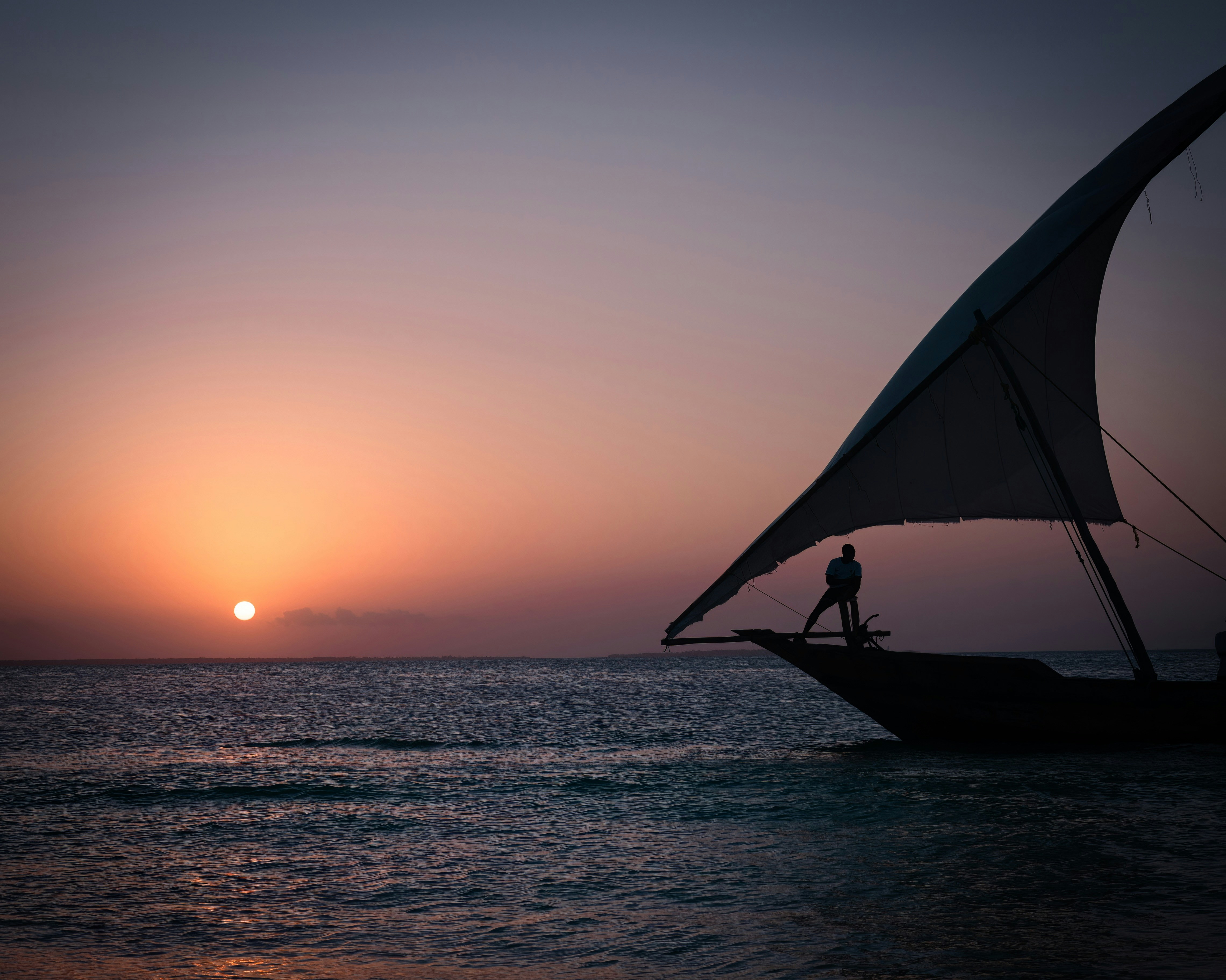Dhow tradicional navegando al atardecer frente a Zanzíbar