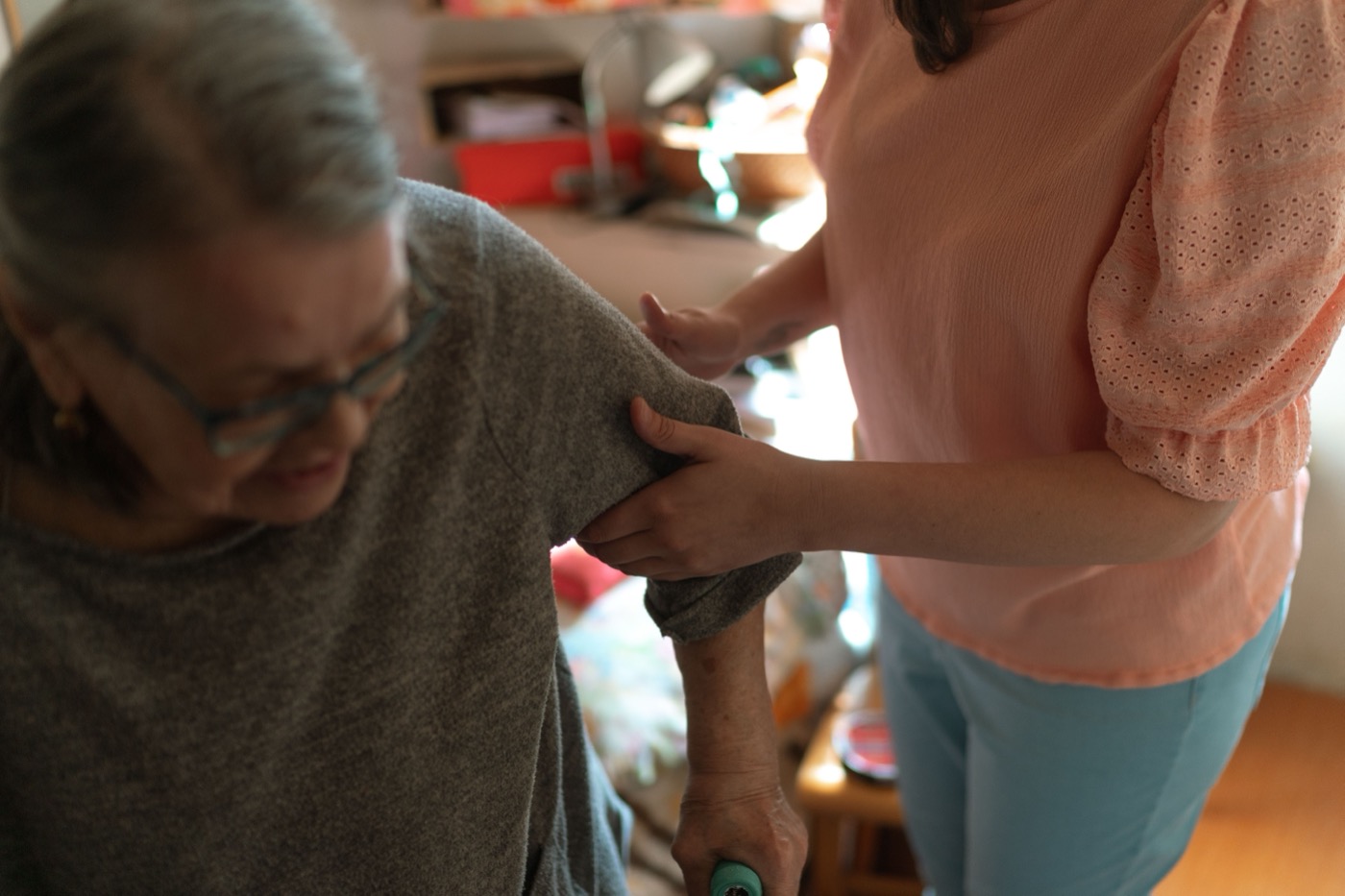 Care worker supporting an older adult with mobility at home