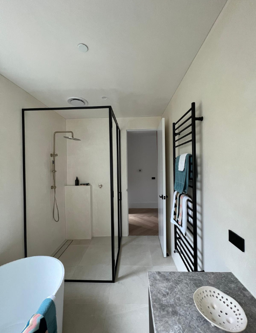 Sleek bathroom with white fire sprinkler positioned above shower and bathtub