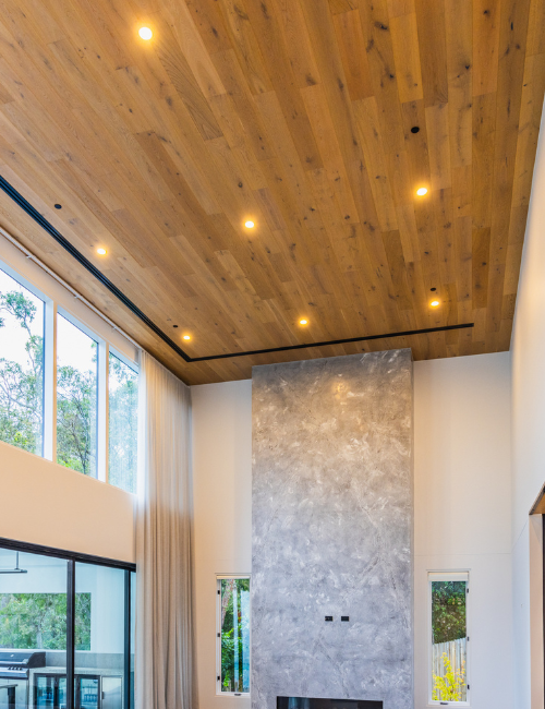 Spacious modern living room with tall glass doors and black fire sprinklers on a wood ceiling