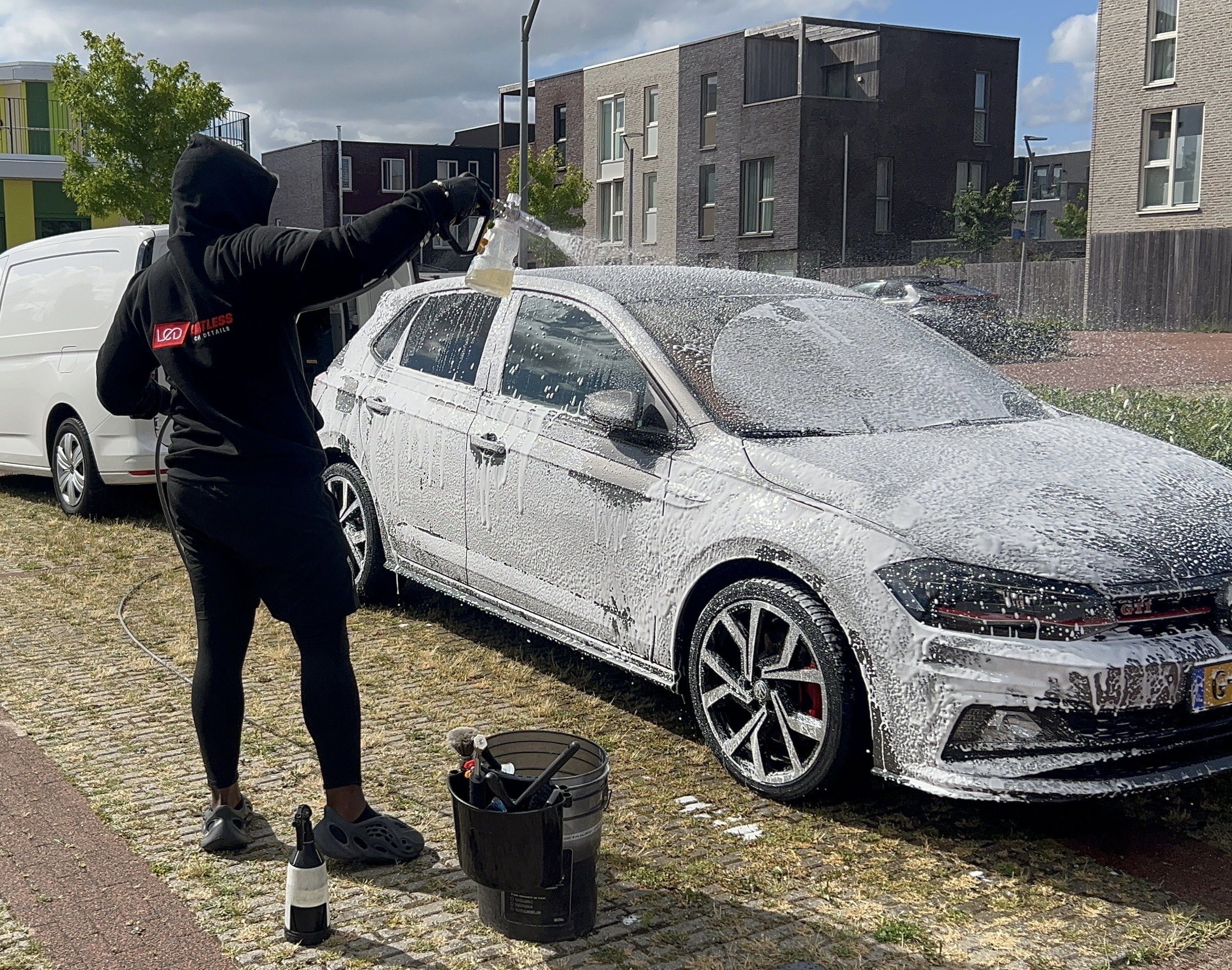 Detailer van Limitless Car Details reinigt een auto op de oprit van een klant