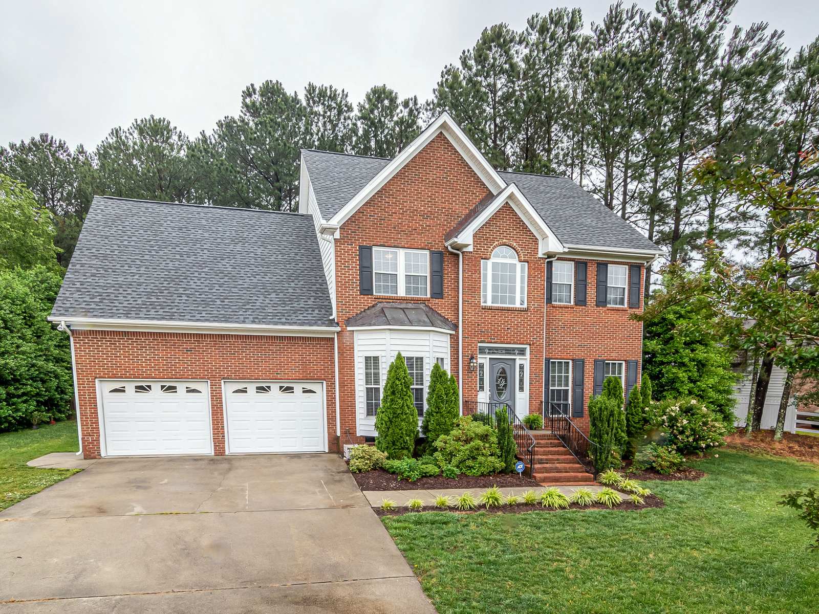 Two-story brick house with a two-car garage and a landscaped front yard