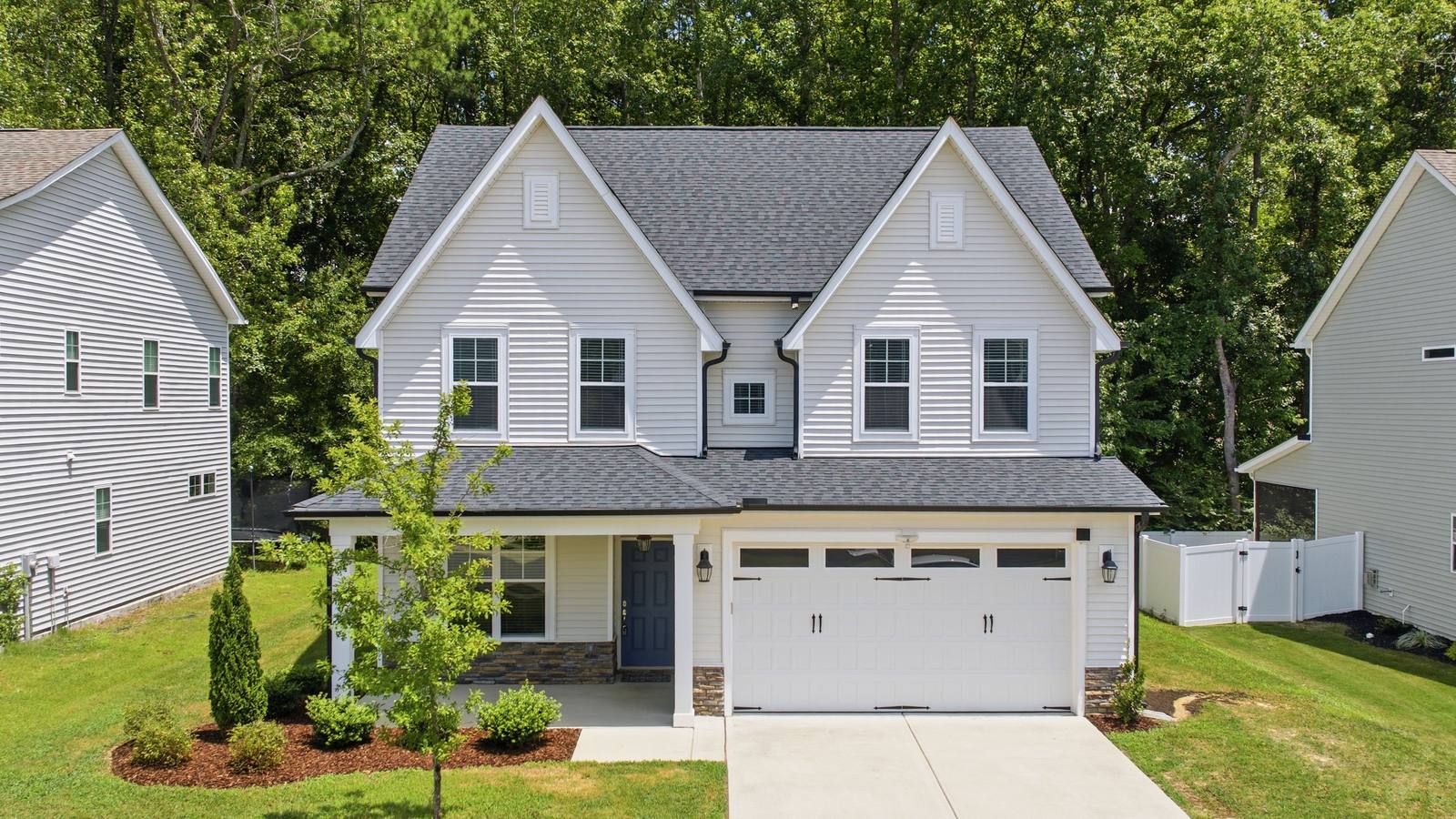 Two-story house with white siding and a two-car garage in a newer subdivision