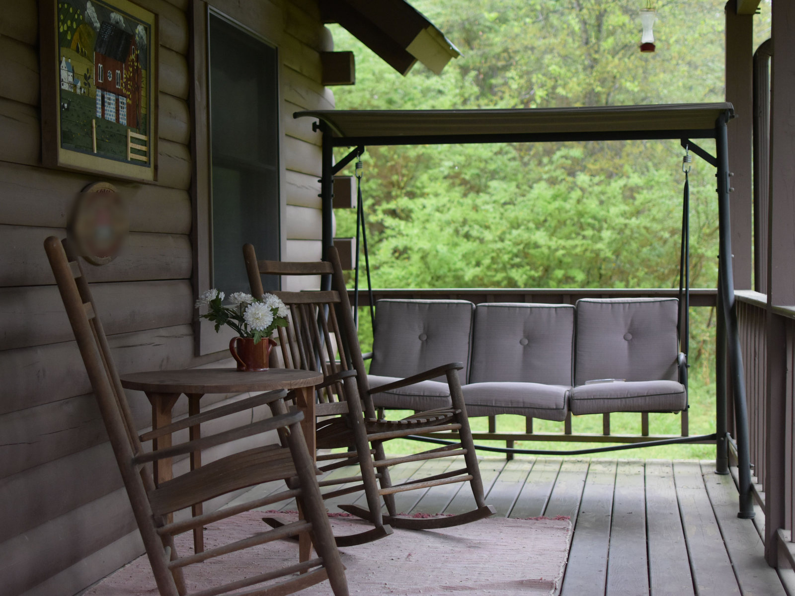 Quiet covered porch with wooden rocking chairs and a porch swing
