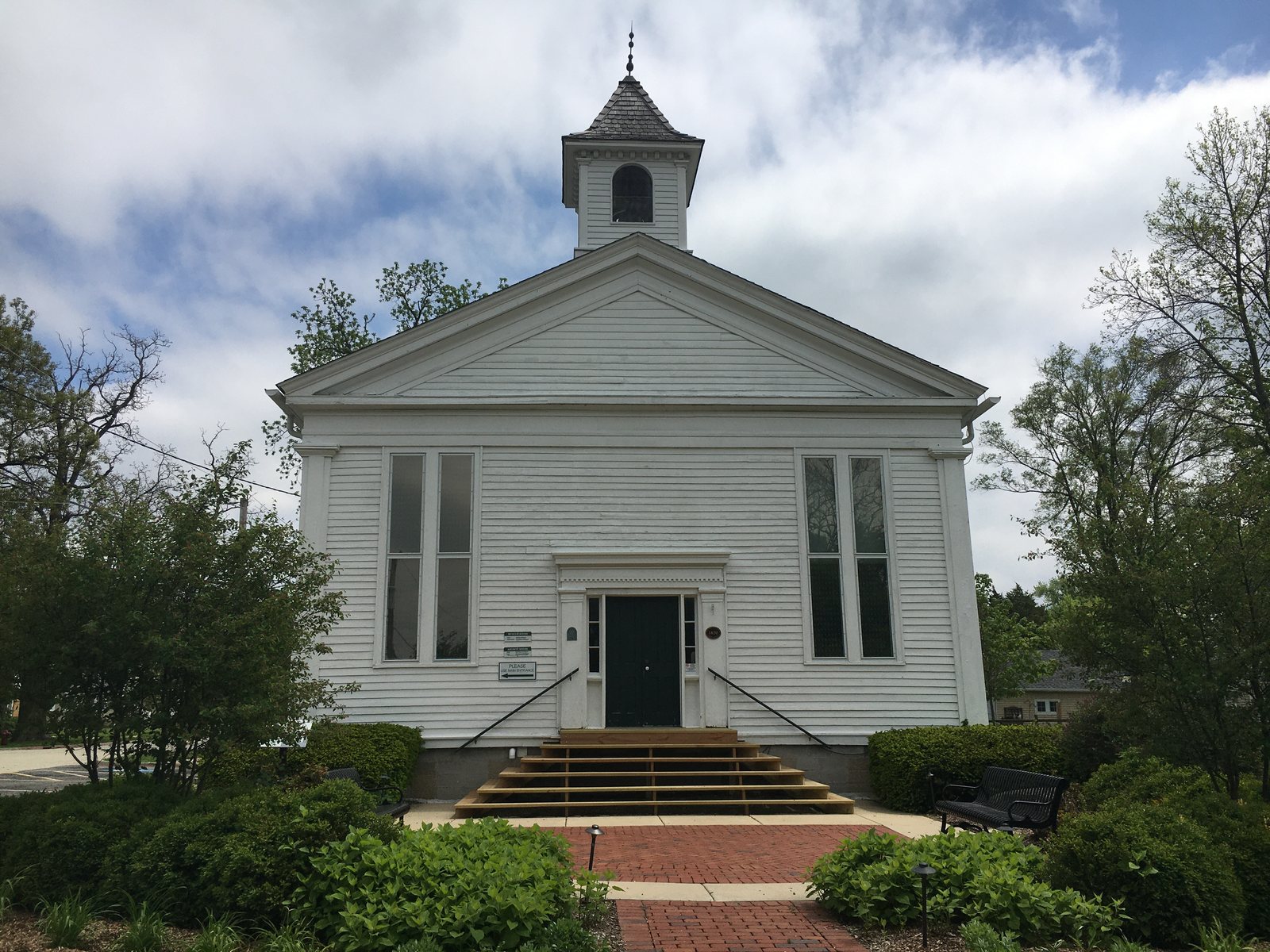 The white Little White School Museum with a small bell tower in downtown Oswego, Kendall County, Illinois
