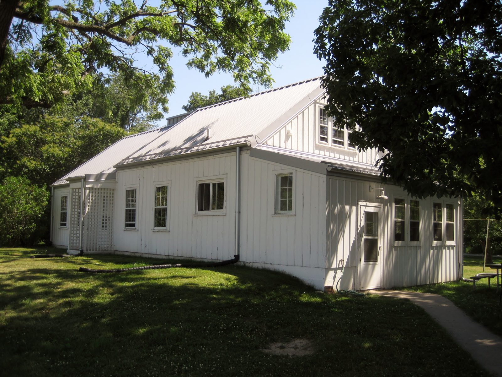 A white farmhouse on a shaded lawn in Illinois