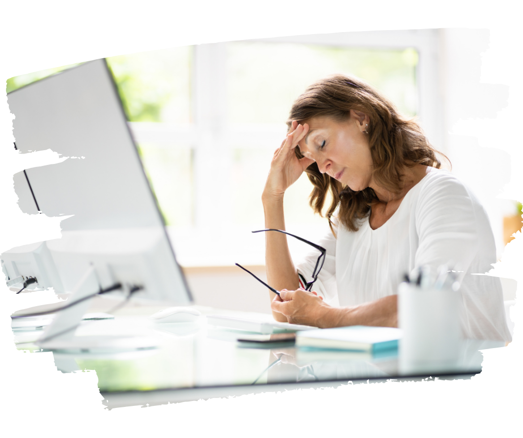 Woman experiencing stress and mental fatigue while working at desk, holding glasses and touching forehead Woman experiencing stress and mental fatigue while working at desk, holding glasses and touching forehead