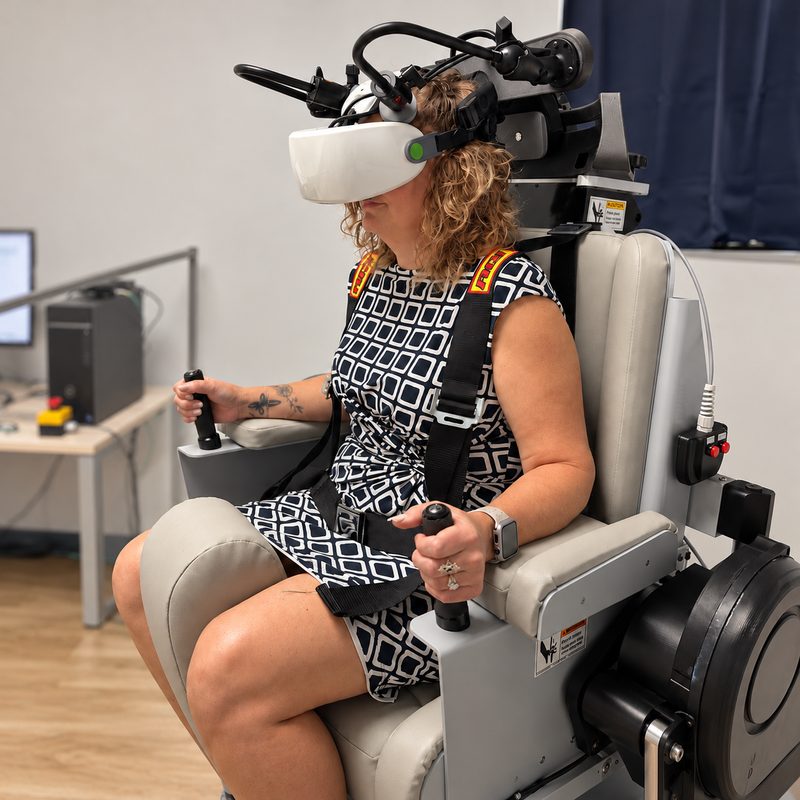 A patient seated in a rotary chair wearing infrared eye-tracking goggles