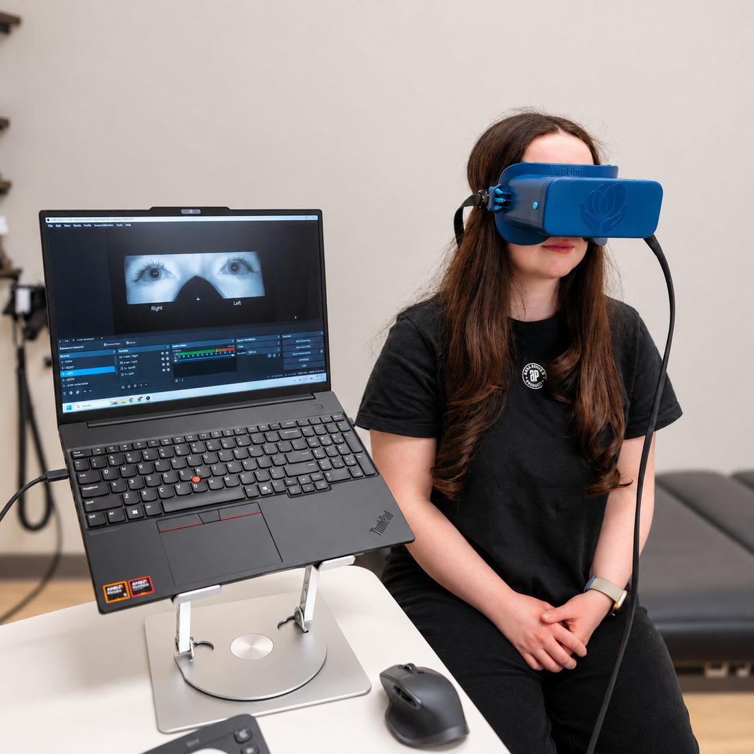 A patient wearing infrared eye-tracking goggles while her eye movements appear on a laptop screen at Cerebral Health