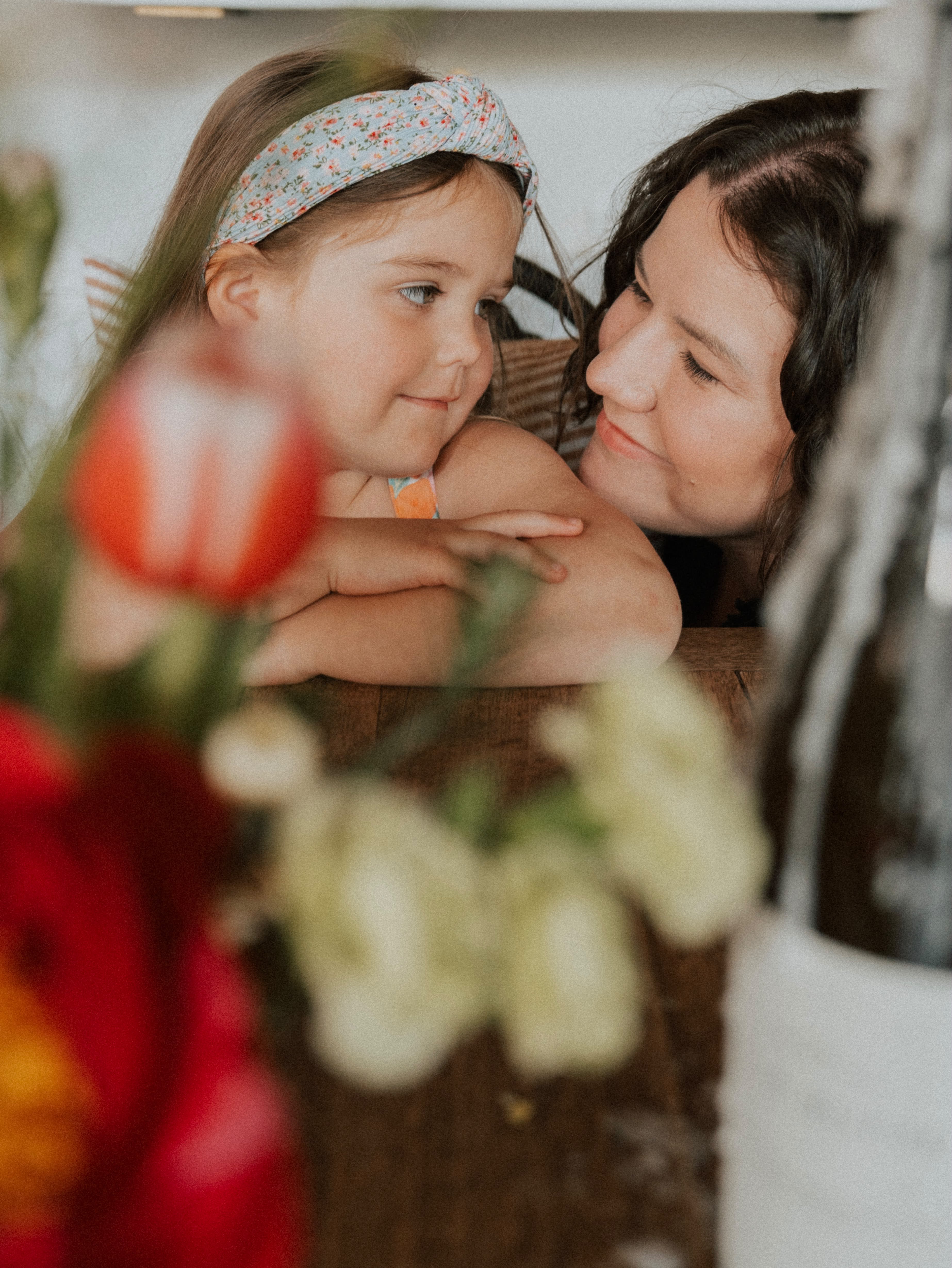 Kelsie and her daughter sharing a quiet moment behind fresh flowers