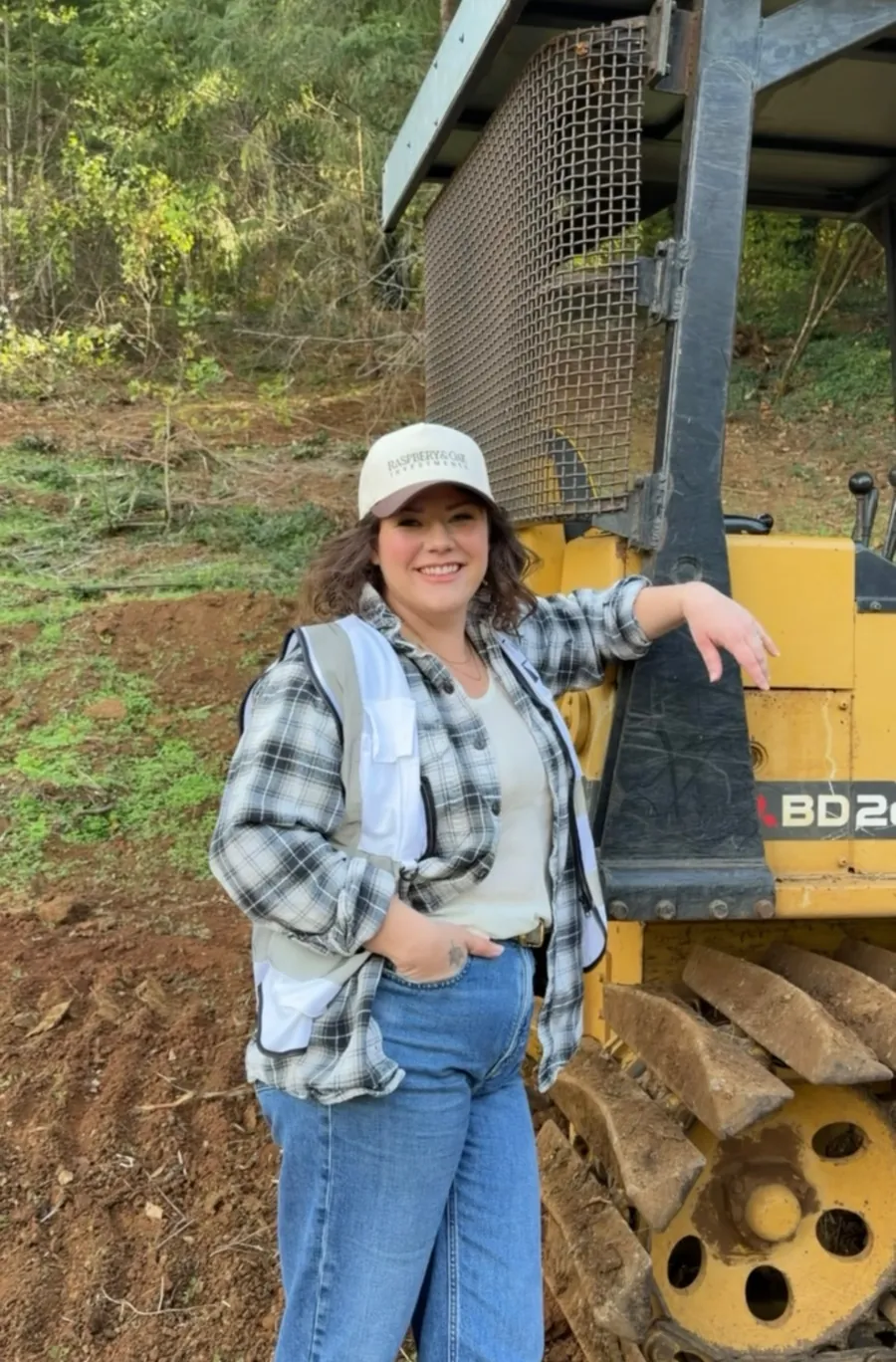 Kelsie, Raspberry & Oak developer, in an R&O Investments cap and safety vest on a cleared building lot