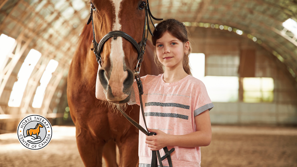 Child standing beside a horse during aba therapy for autism session