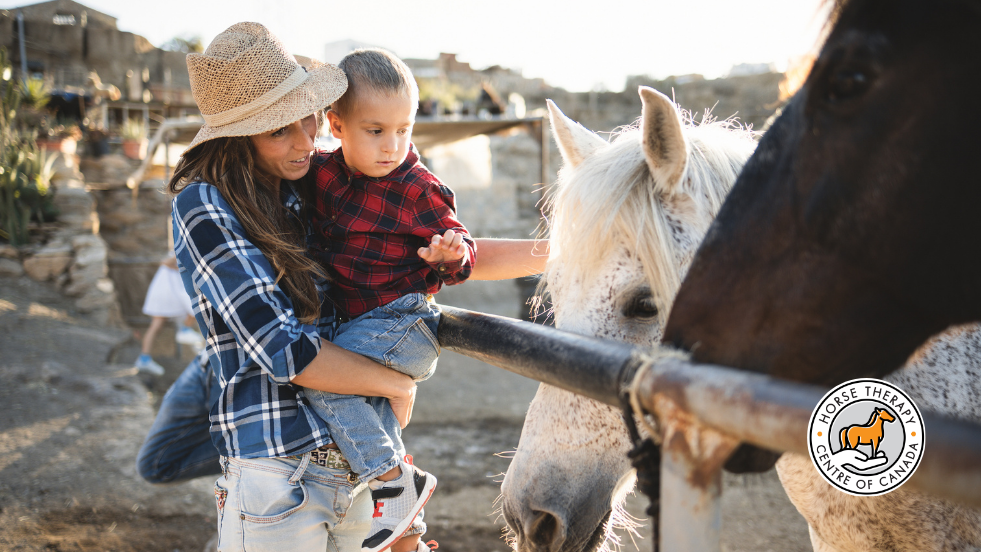 Parent and child interacting with horses in therapy for kids program