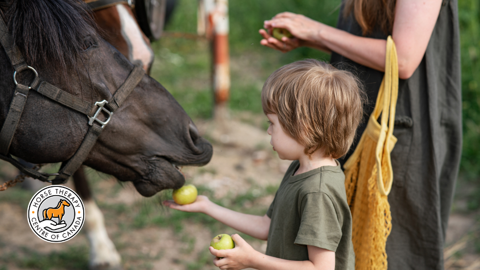 Child reaching toward a horse during therapy for kids session