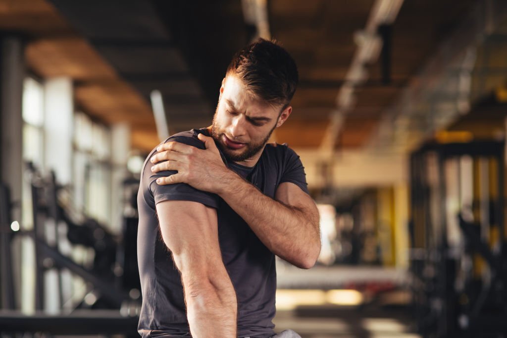 An adult holding a sore shoulder