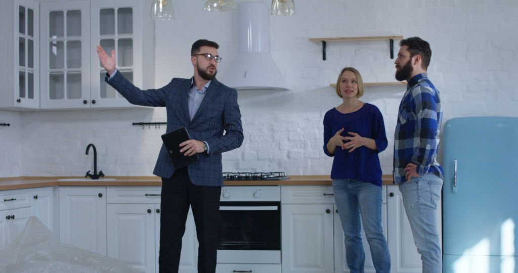 An inspector walking a couple through a kitchen