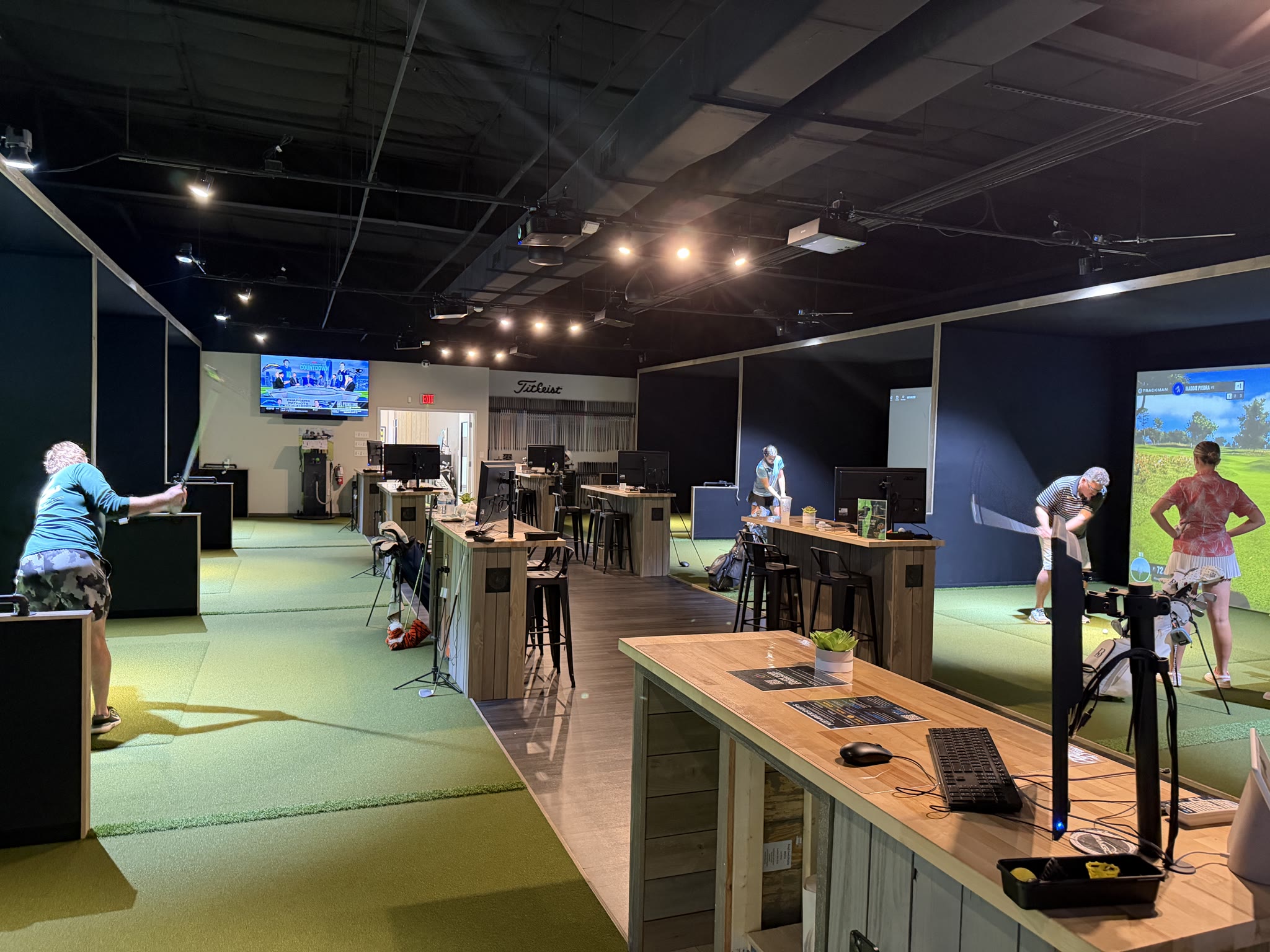 Real view inside Athletic Motion Golf Club showing the open golf bays, central aisle and seating