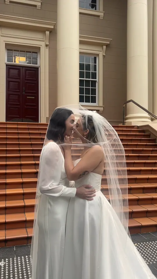 Brooke and Ashleigh sharing a kiss on the steps