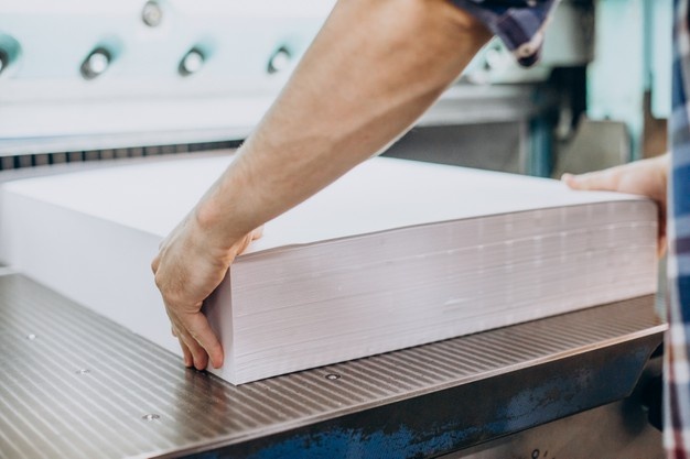 Loading paper into the printing press at The Print Office