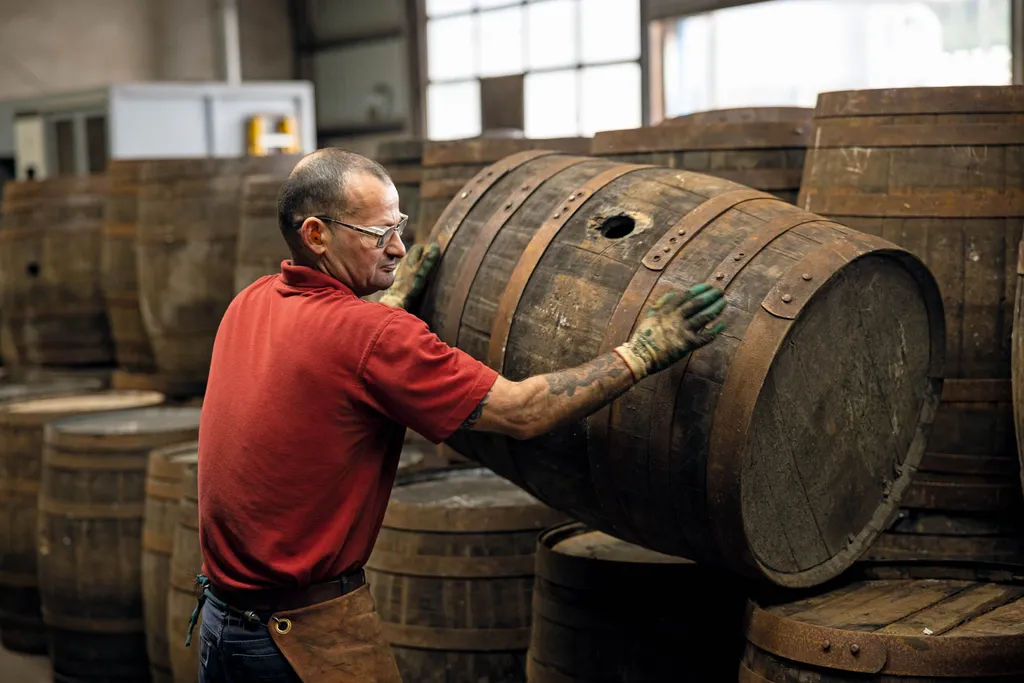 One of the coopers at Speyside Cooperage, stacks a finished barrel. Image credit: Jeremy Flint.