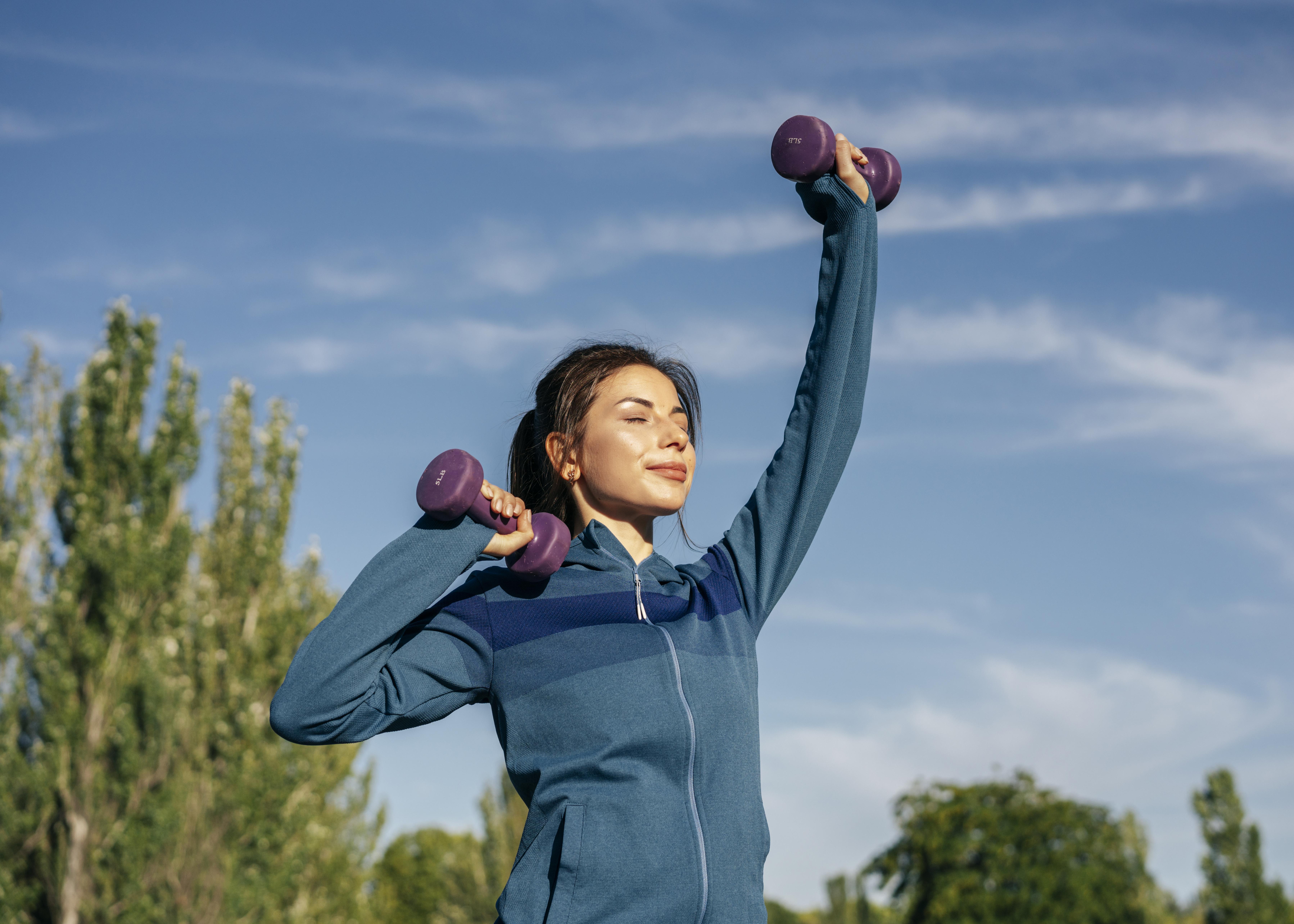 Woman staying active outdoors with light weights, supporting energy through the day