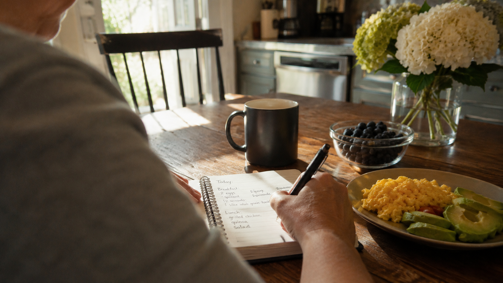 "quiet moment of a person journaling meals at a kitchen table during a weight loss protocol"