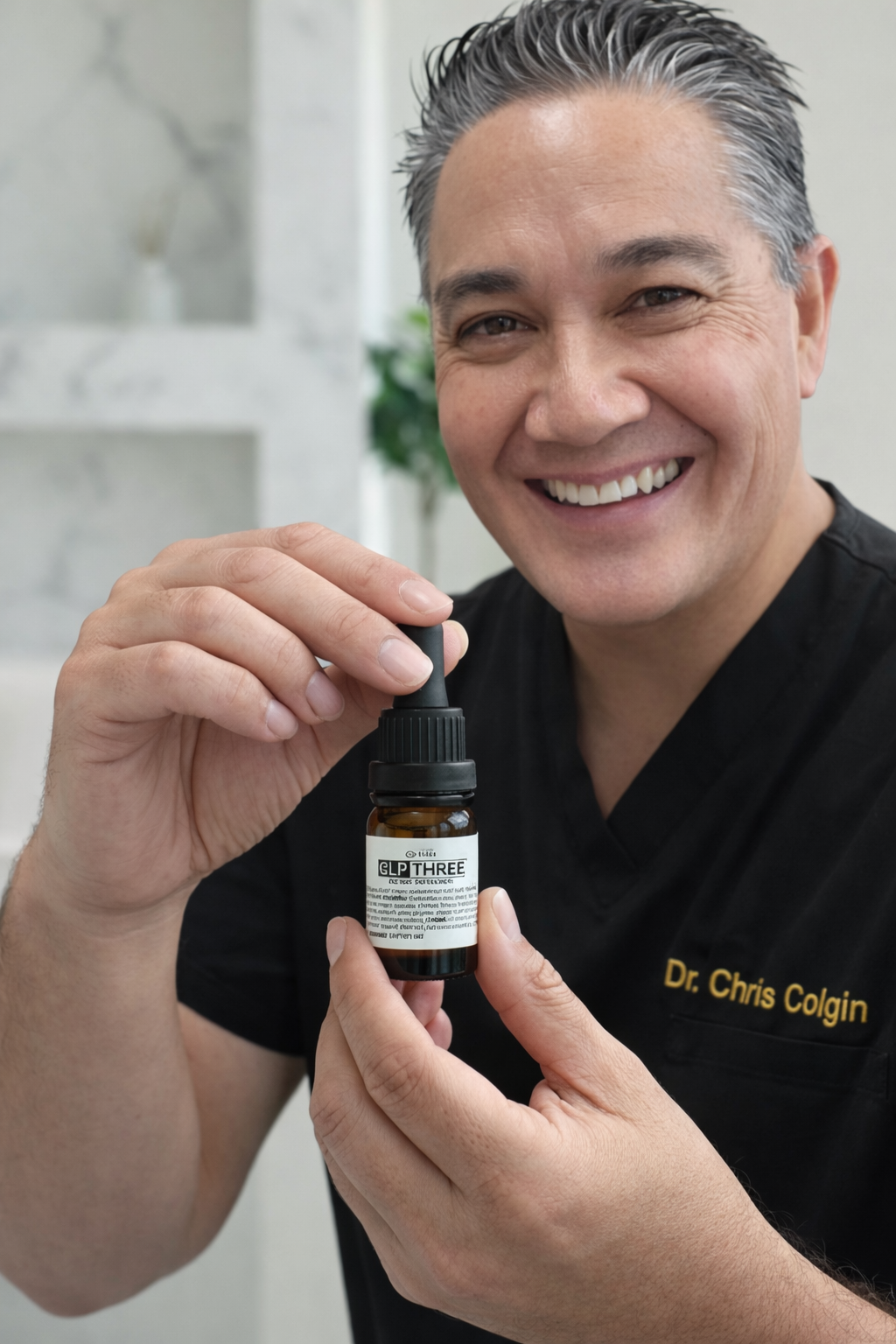 Dr. Chris Colgin holding a bottle of GLP THREE, wearing black scrubs embroidered with his name