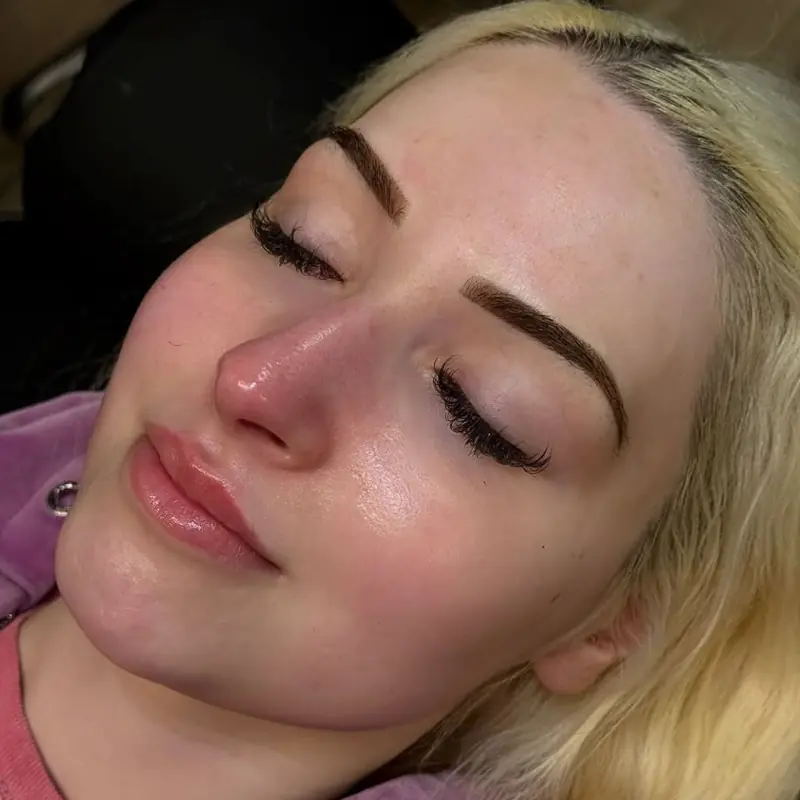 Client with soft, full permanent brows and a natural arch