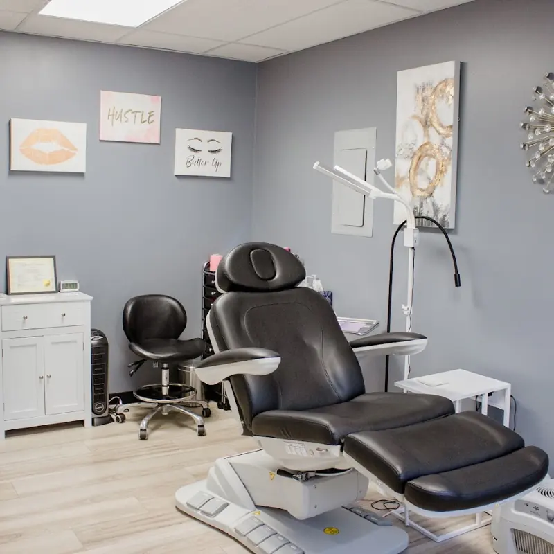 Tasha's Browtique treatment room with a black treatment chair and framed art