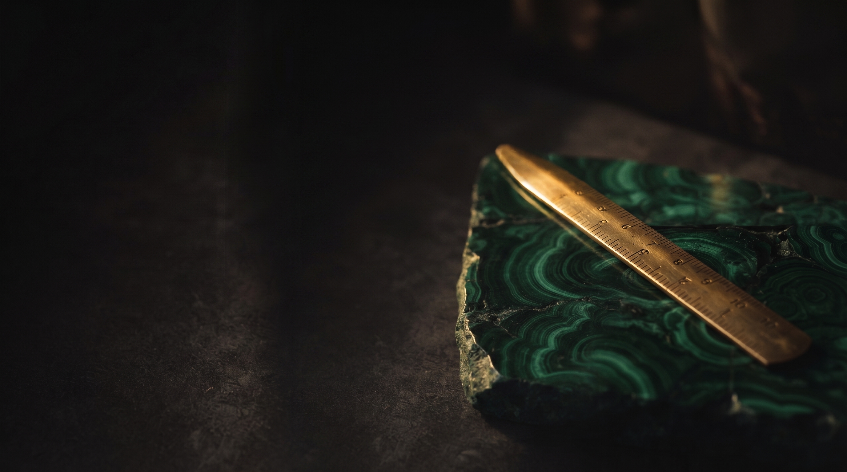 Brass ruler on green stone