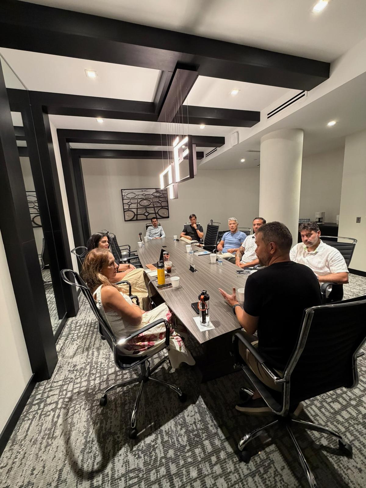Reunião íntima em sala executiva durante uma call de acompanhamento do PLANO CAPITAL