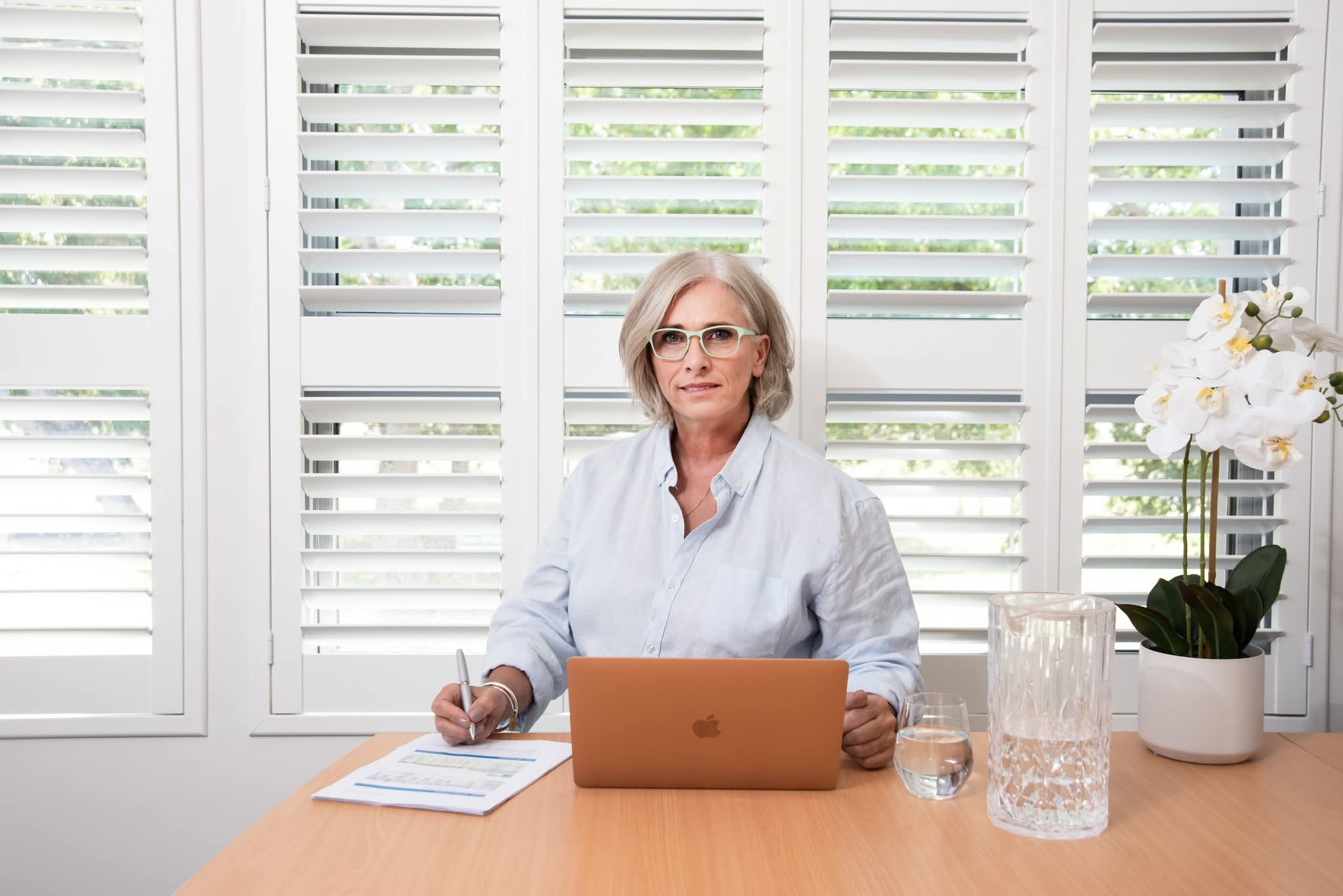 Sue Rusalen seated at a desk with a laptop