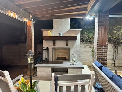 Outdoor fireplace and seating area with a wooden pergola