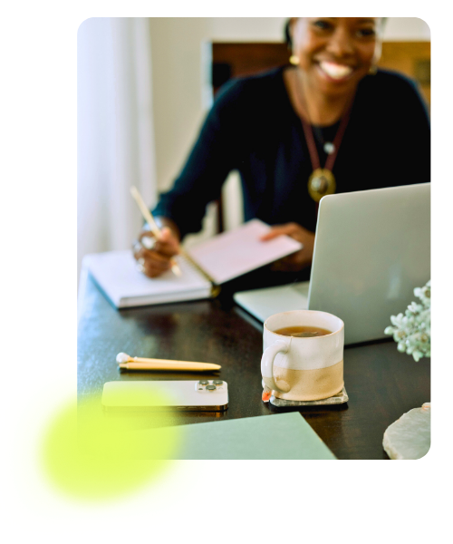 Woman smiling working on her laptop at a table
